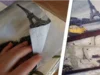 Hand faltet Serviette mit Eiffelturm-Motiv