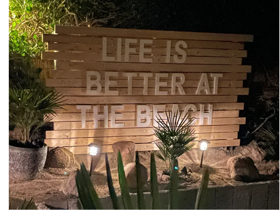 Holzschild mit der Aufschrift "Life is better at the beach".