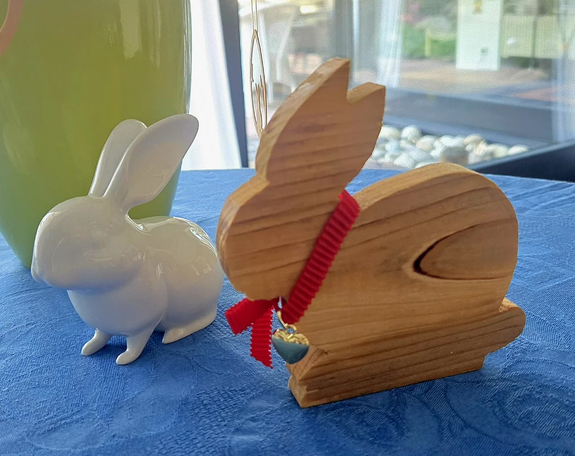 Zwei Osterhasen aus Holz und Keramik als Dekoration.