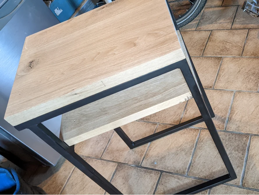Kleiner Tisch mit Holzplatte und Metallrahmen