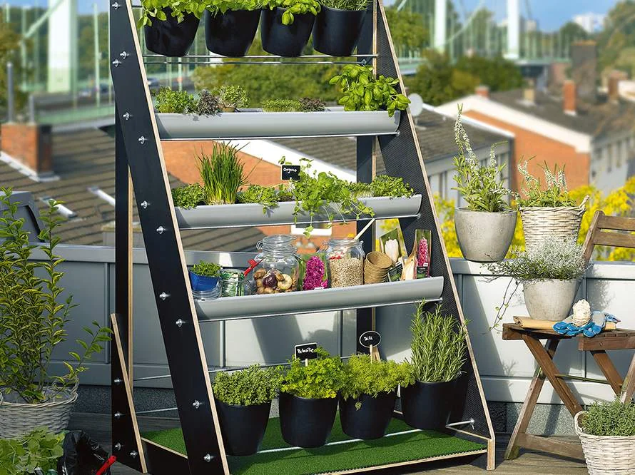 Vertikaler Garten auf einem Balkon mit Kräutern und Blumen.