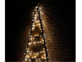 Rustikaler Holz-Weihnachtsbaum mit Lichterkette an Backsteinwand
