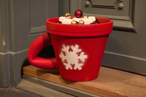 Eine große rote Tasse mit einer Schneeflocke als Weihnachtsdekoration.