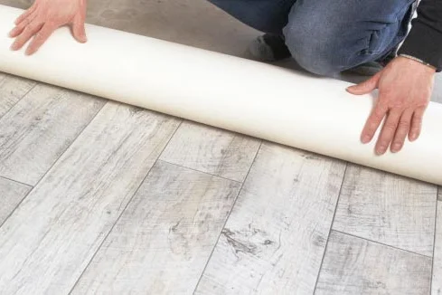 Person rollt Vinylboden aus