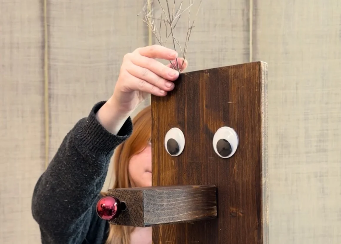 Eine Person bastelt ein Rentier aus Holz als Weihnachtsdekoration.