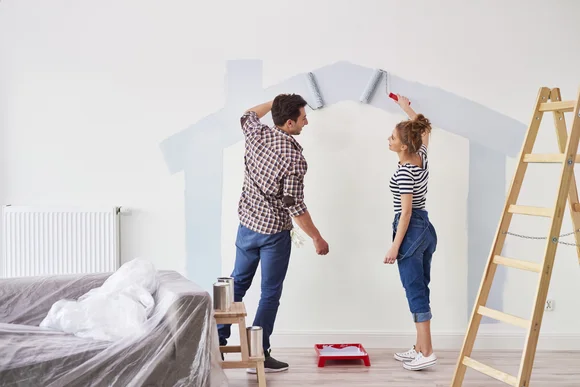 Zwei Personen streichen Wand