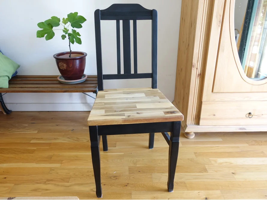 Schwarzer Stuhl mit Holzsitzfläche