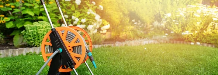 Gartenschlauch auf einem Schlauchwagen im Garten