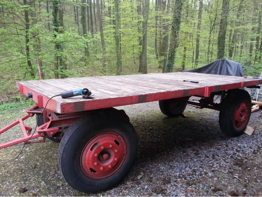 Roter Anhänger mit Holzplatte und Winkelschleifer