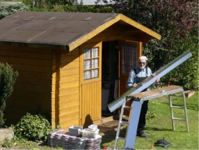 Person baut ein Gartenhaus