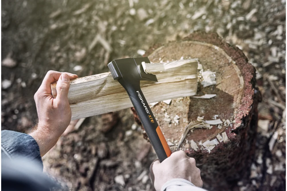 Person hackt Holz mit Axt
