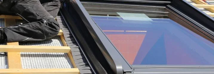 Person montiert Dachfenster