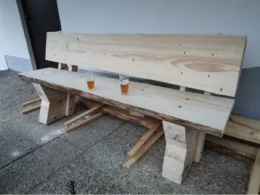 Unfertige Holzbank mit zwei Gläsern Bier darauf