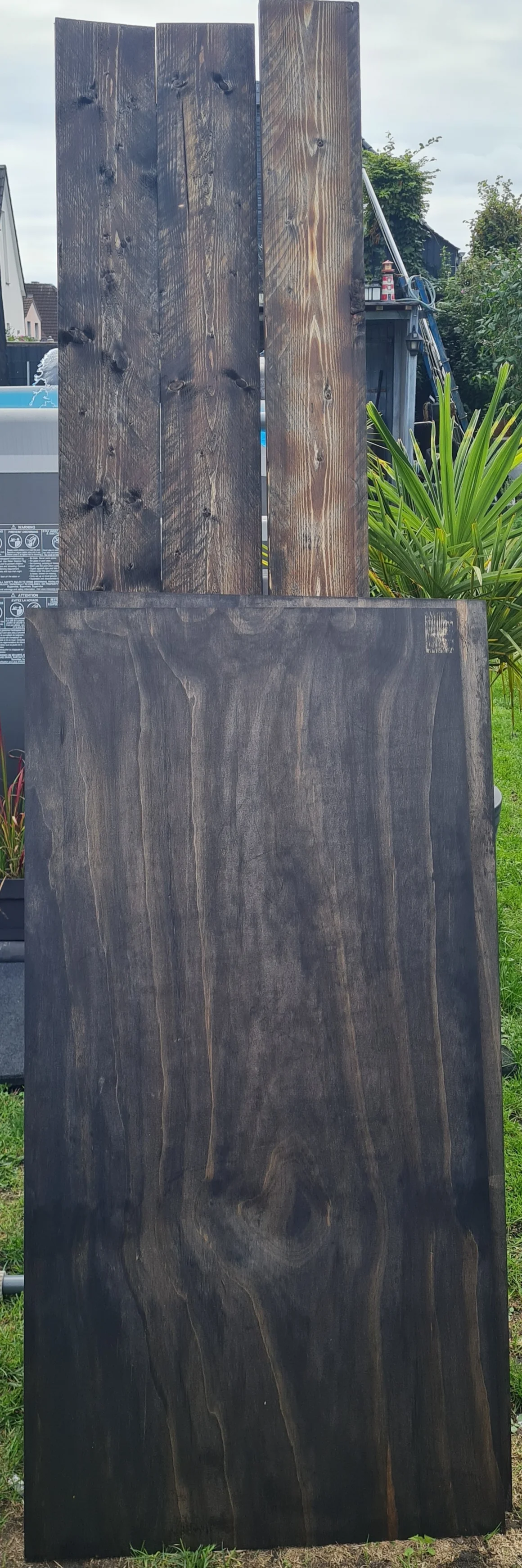 Dunkel lasierte Holzbretter für ein Bauprojekt.