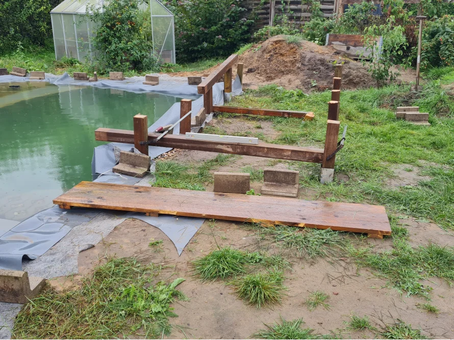 Holzgerüst mit Wasserwaage am Teich