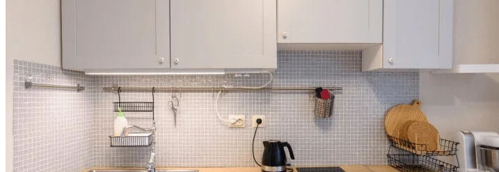 Moderne Küche mit grauen Schränken und Holzarbeitsplatte