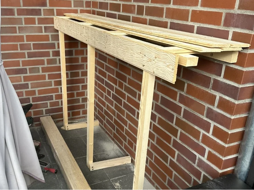 Holzgestell an Backsteinwand