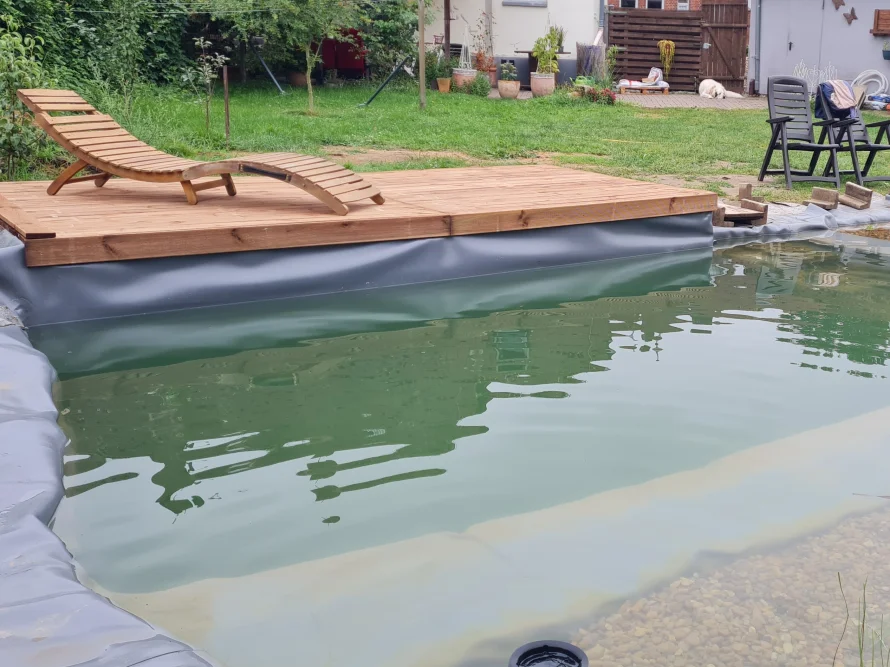 Schwimmteich mit Holzterrasse und Liege