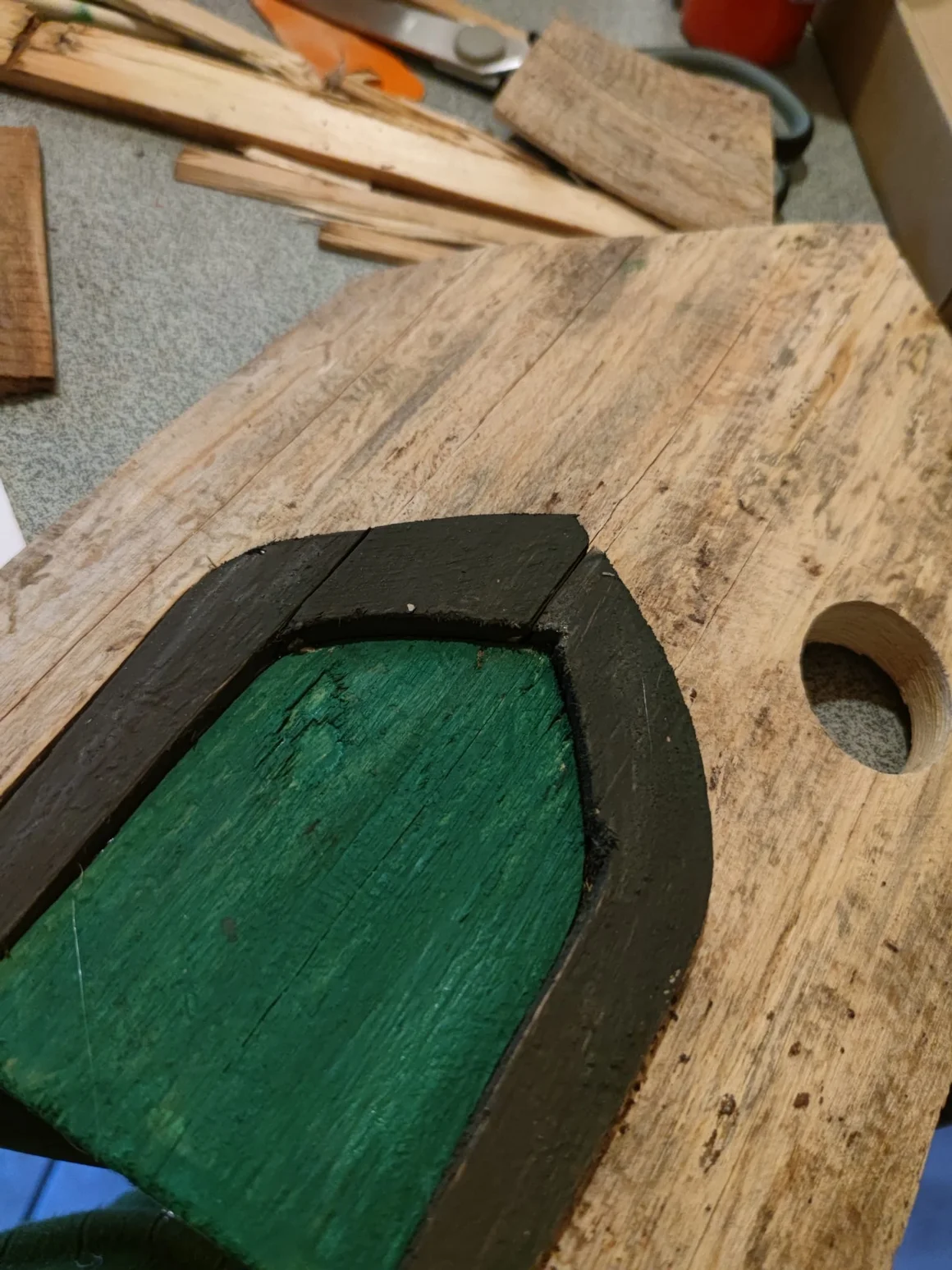 Ein selbstgebautes Vogelhaus aus Holz mit einer grünen Tür.