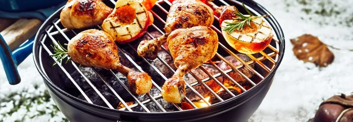 Hähnchen und Pfirsiche auf einem Grill im Schnee