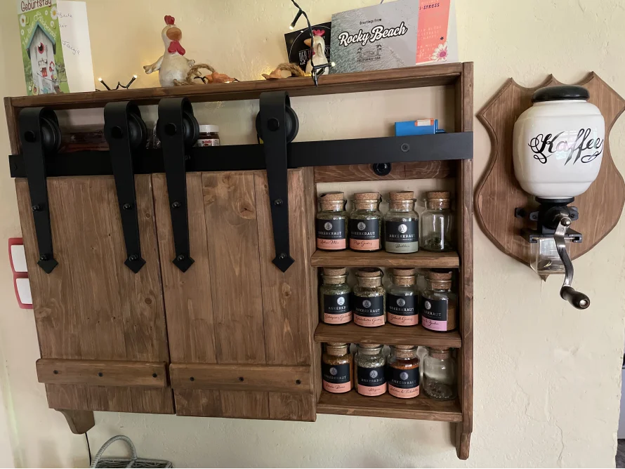 Ein rustikales Gewürzregal mit Schiebetüren aus Holz.