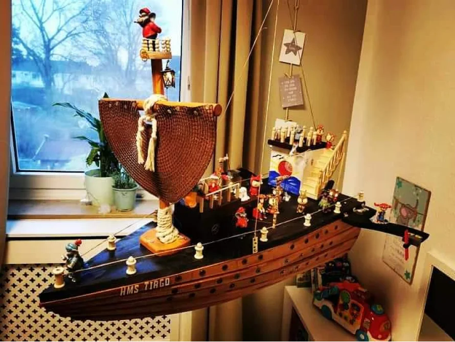 Ein selbstgebautes Spielzeugschiff hängt an der Decke.