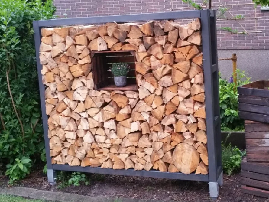 Holzstapel mit Pflanze in einem Metallgestell