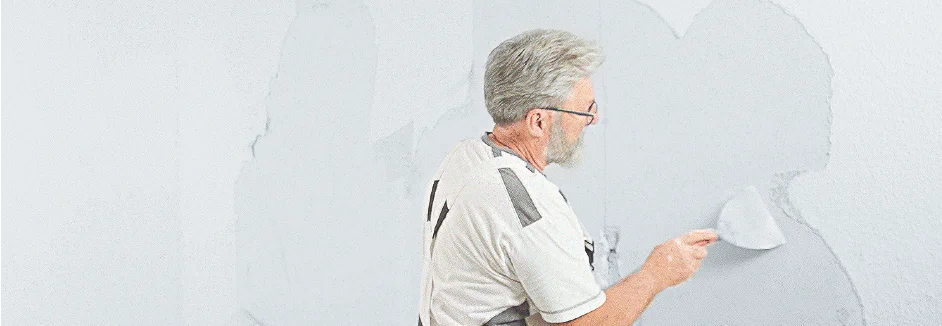 Person verputzt Wand mit Kelle