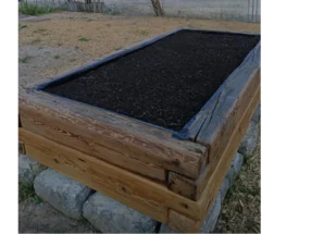 Erhöhtes Gartenbeet aus Holz gefüllt mit Erde