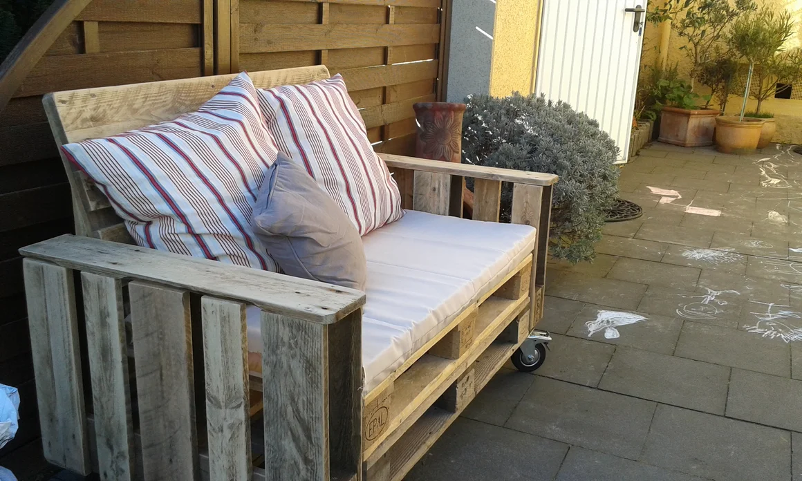 Palettensofa mit Kissen im Garten
