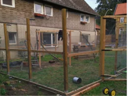 Ein umzäuntes Gehege mit Holzrahmen im Garten