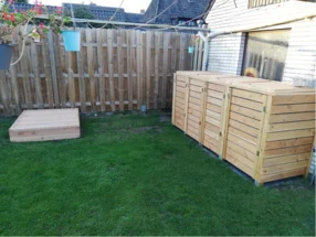 Garten mit Holzmülltonnenverkleidung und Sandkasten