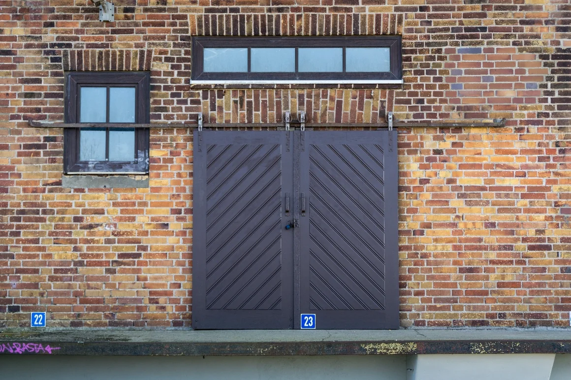 Braune Schiebetür in Backsteinwand