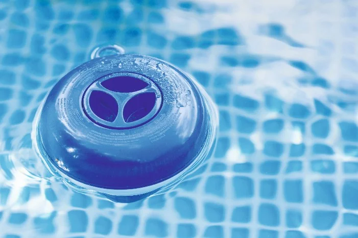 Ein Chlordosierer schwimmt im Pool