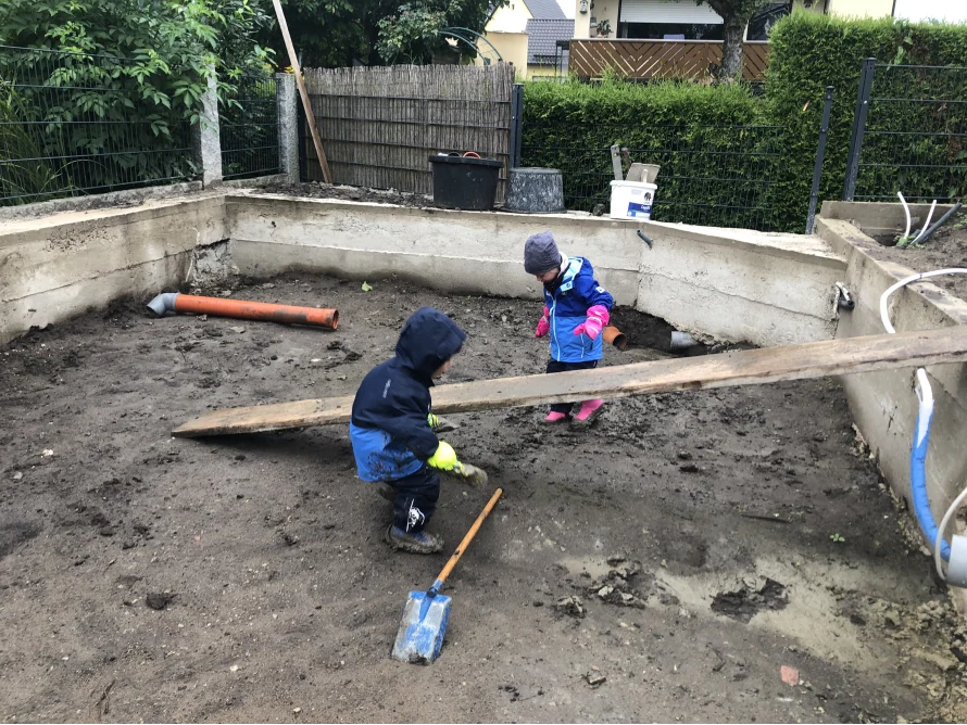 Zwei Kinder spielen auf einer Baustelle