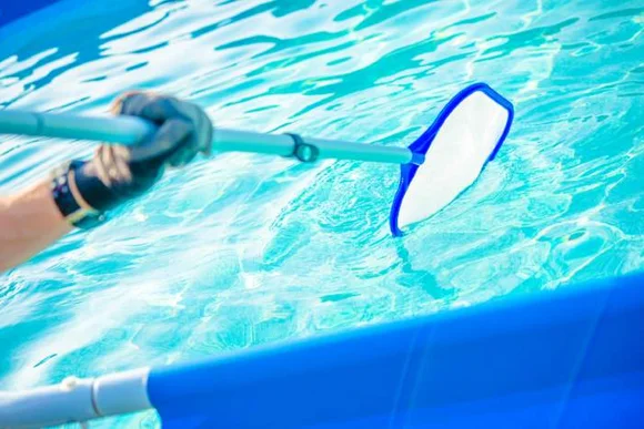 Hand reinigt Pool mit Kescher