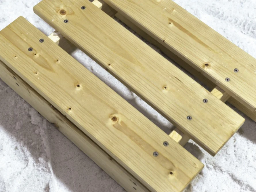 Ein Schlitten mit Holzlatten auf Schnee