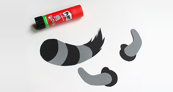 Bastelmaterial: Waschbären-Schwanz und Ohren aus Papier, Klebestift